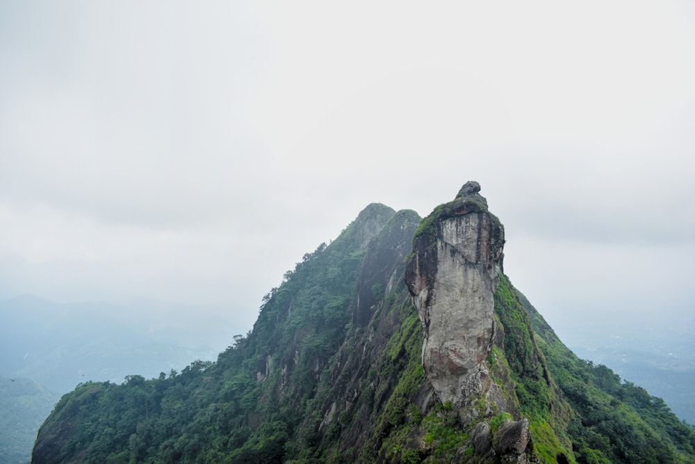 una montaña alta con una estatua en la cima