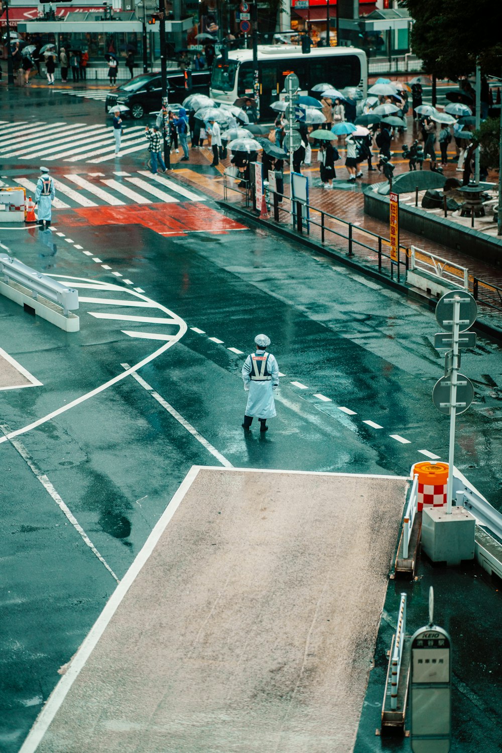 a person walking across a street in the rain