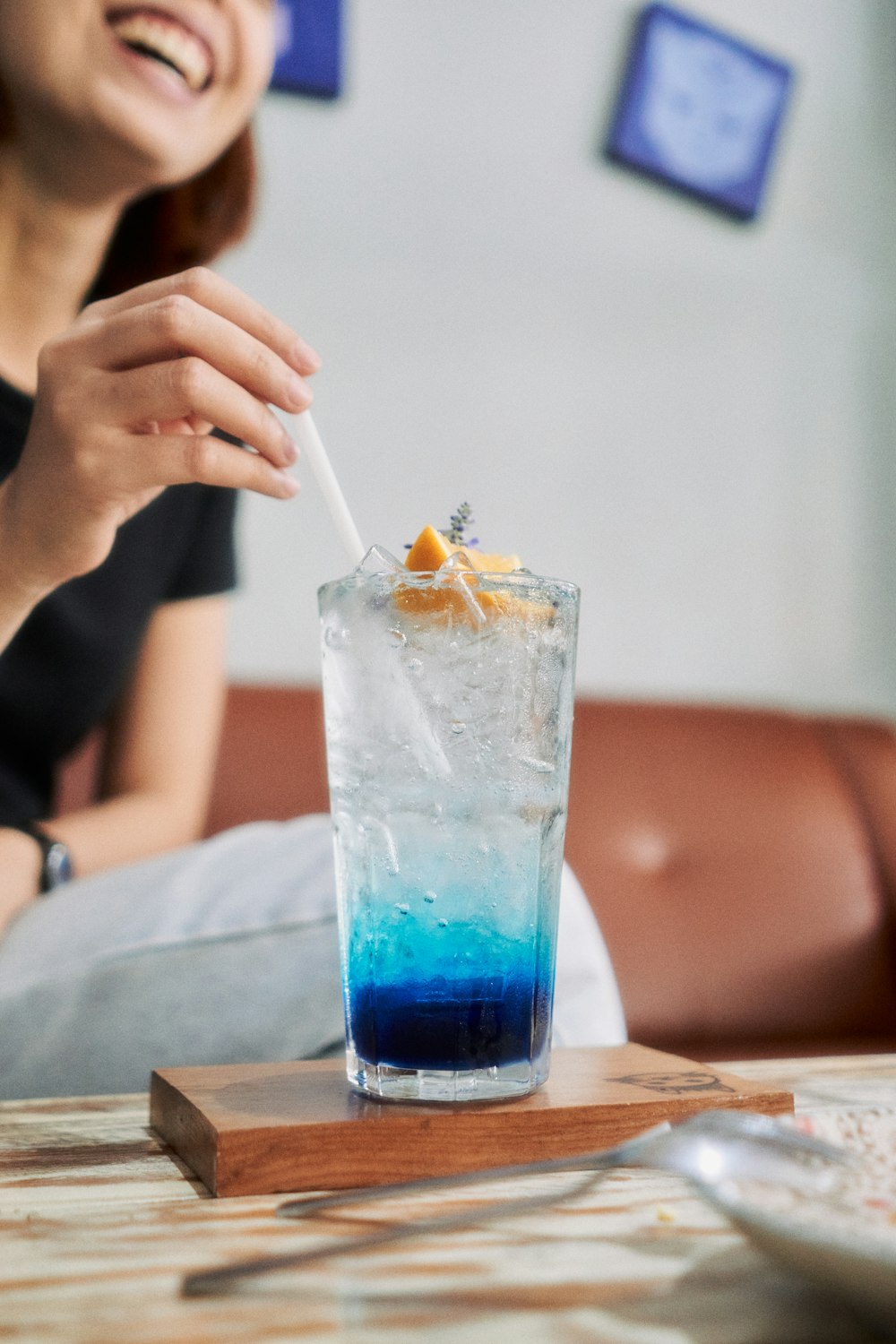 a woman sitting at a table with a drink in front of her