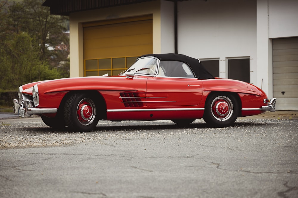 a red sports car parked in front of a garage