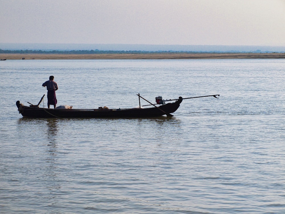 a man standing on a boat in the water