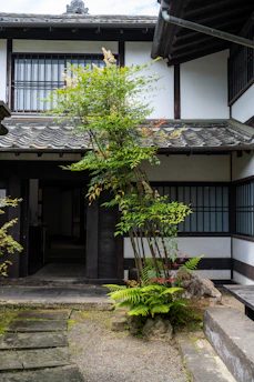 A welcoming Japanese home with a modern design and a garden in front.