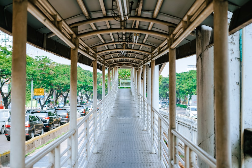a covered walkway with cars parked on both sides