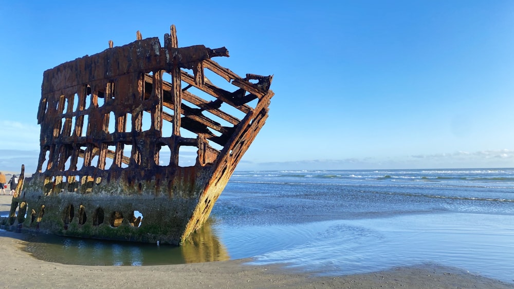 a rusted ship sitting on top of a sandy beach