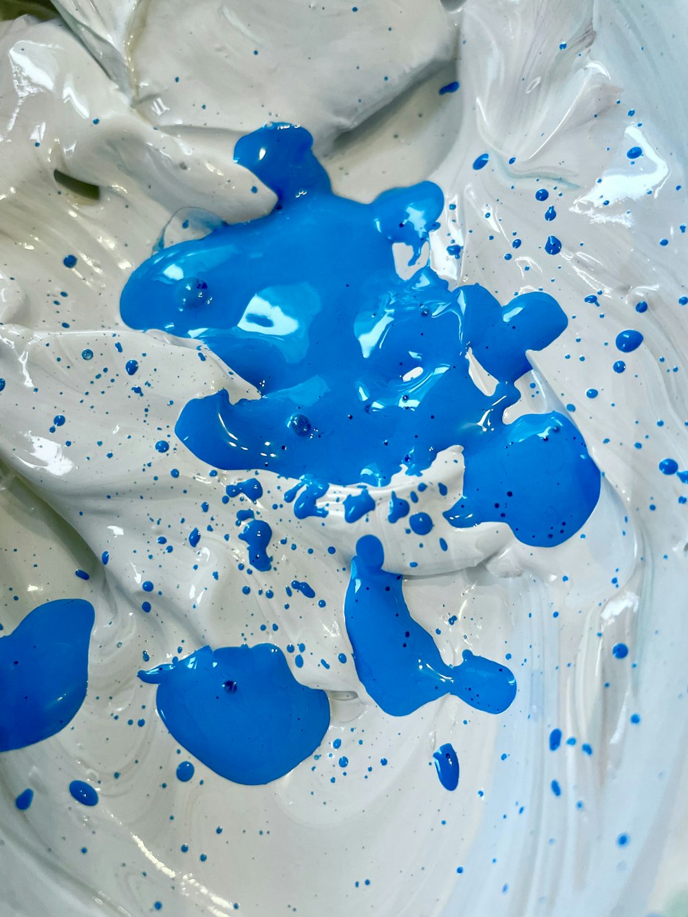blue and white paint is in a bowl
