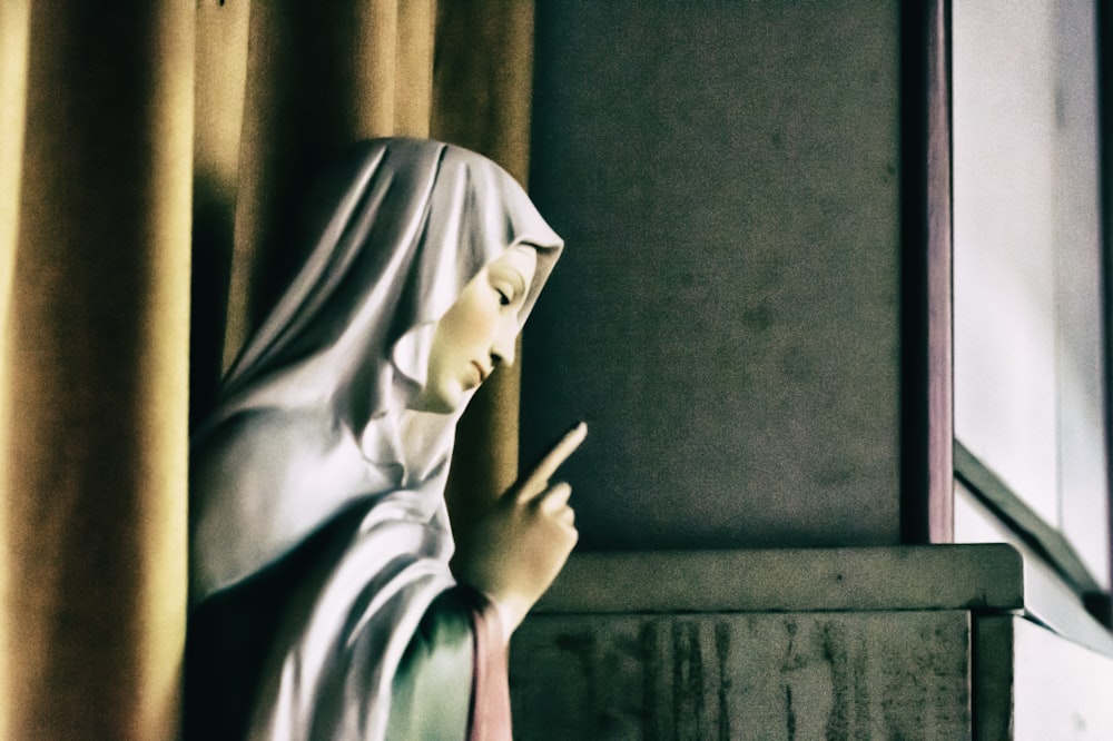une statue d’une religieuse tenant une croix