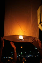 Children releasing biodegradable lanterns into the evening sky, symbolising remembrance and hope.