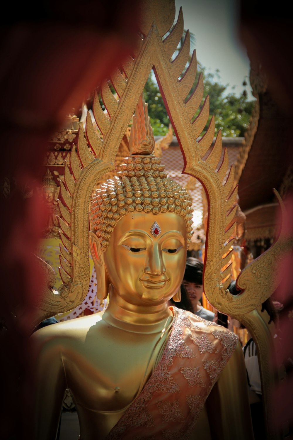 a golden buddha statue sitting in front of a building