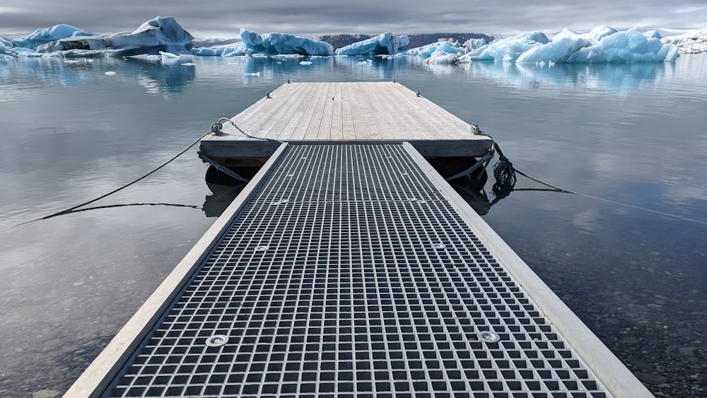 a boat is docked in the water with icebergs in the background