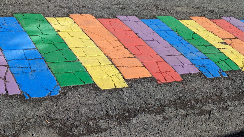 a row of colored bricks sitting on the side of a road