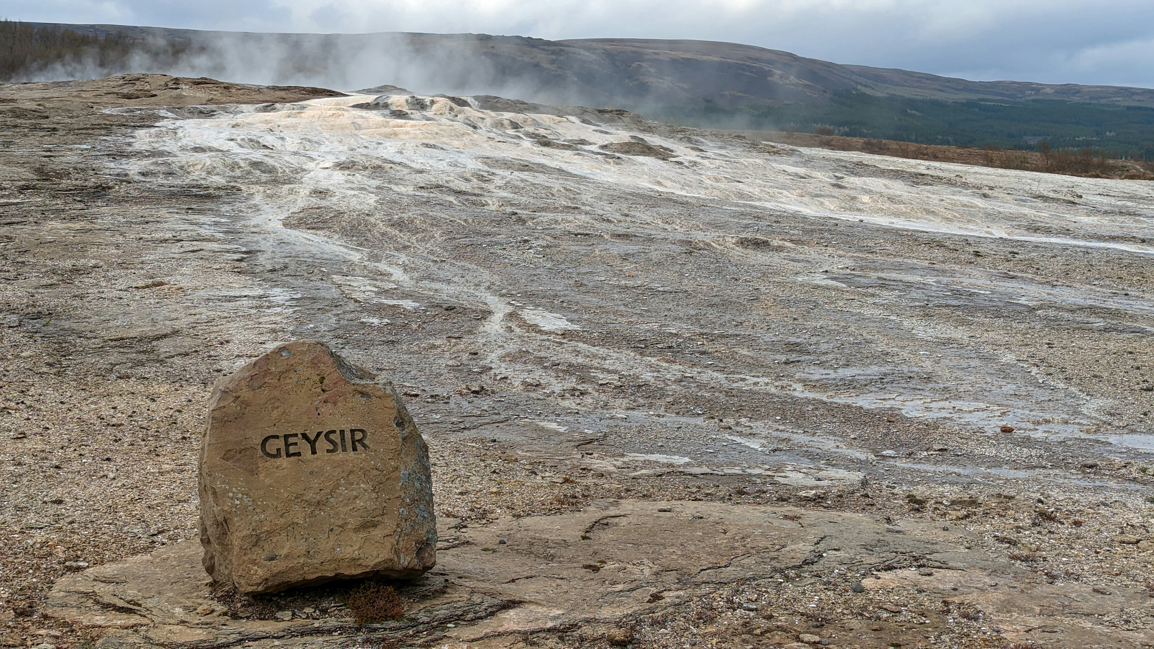 a large rock sitting on top of a dirt field