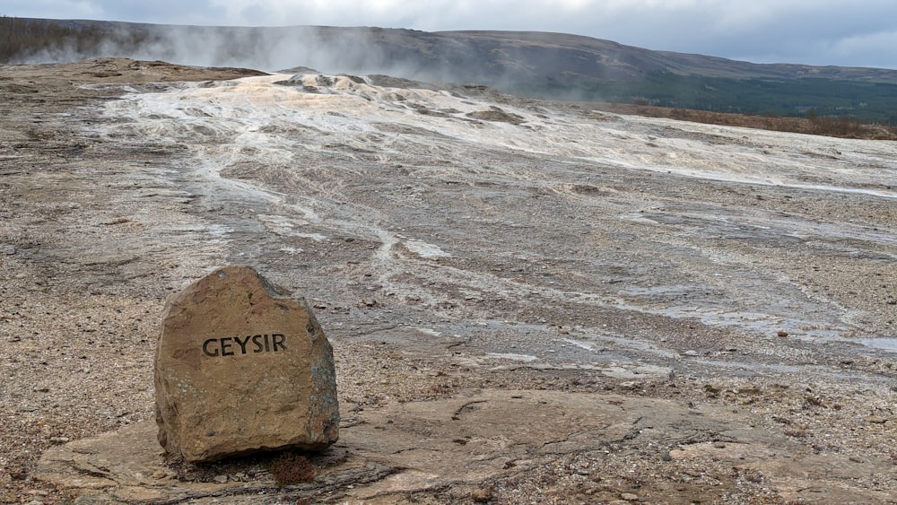 a large rock sitting on top of a dirt field