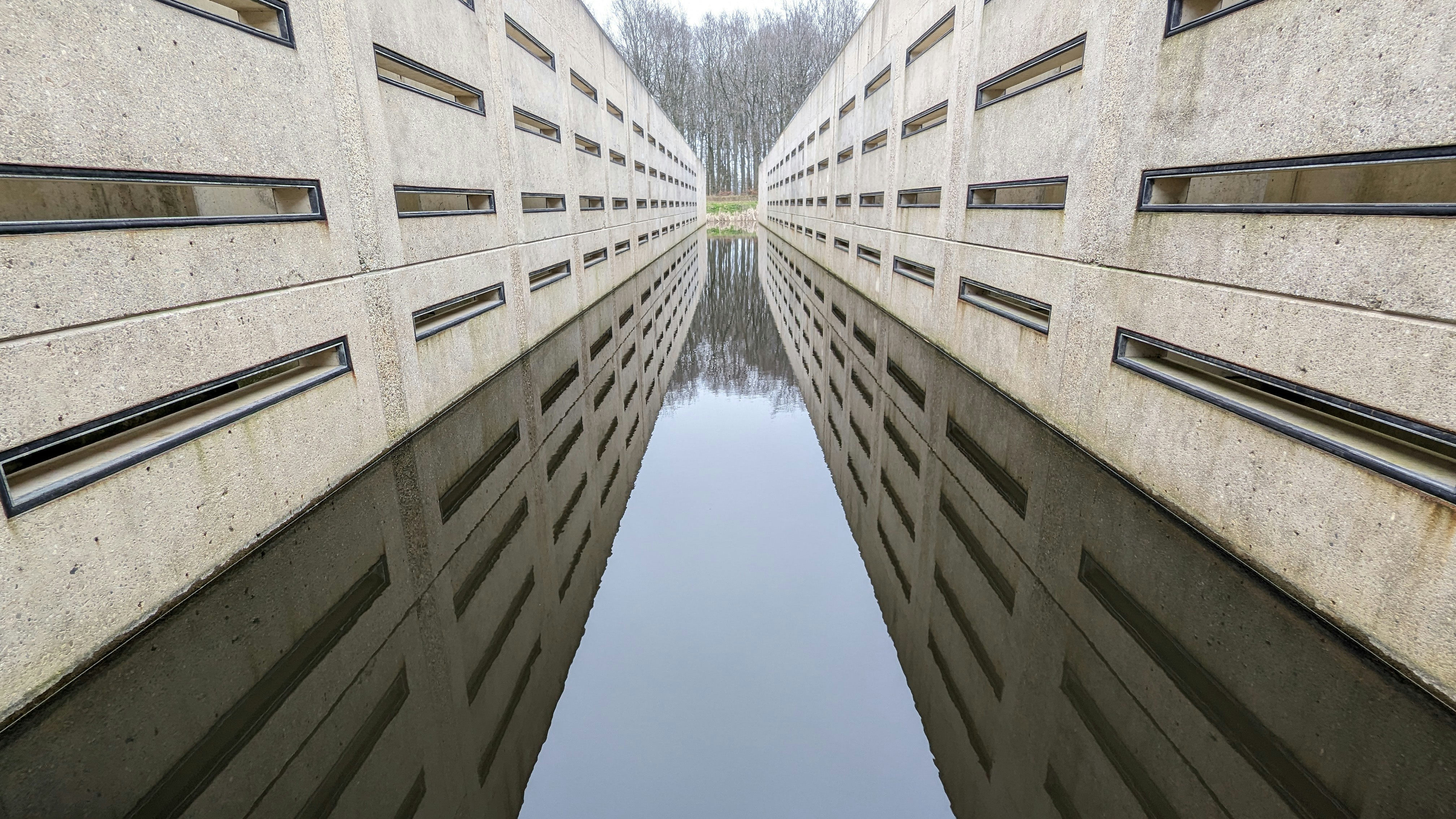 a reflection of a building in a pool of water
