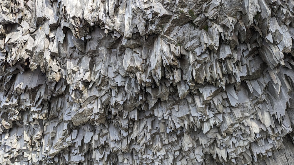 a close up of a rock wall with many rocks on it