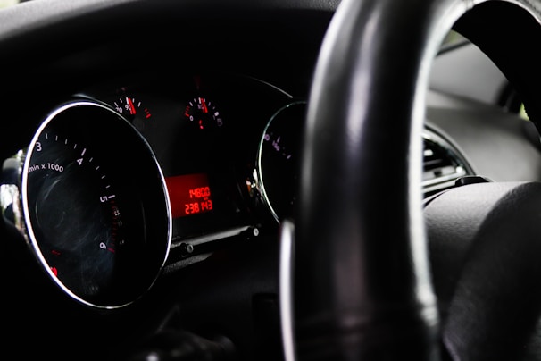A close-up view of a car's dashboard featuring a speedometer, tachometer, and a digital odometer display showing a reading of 148800. The steering wheel is partially visible in the foreground.