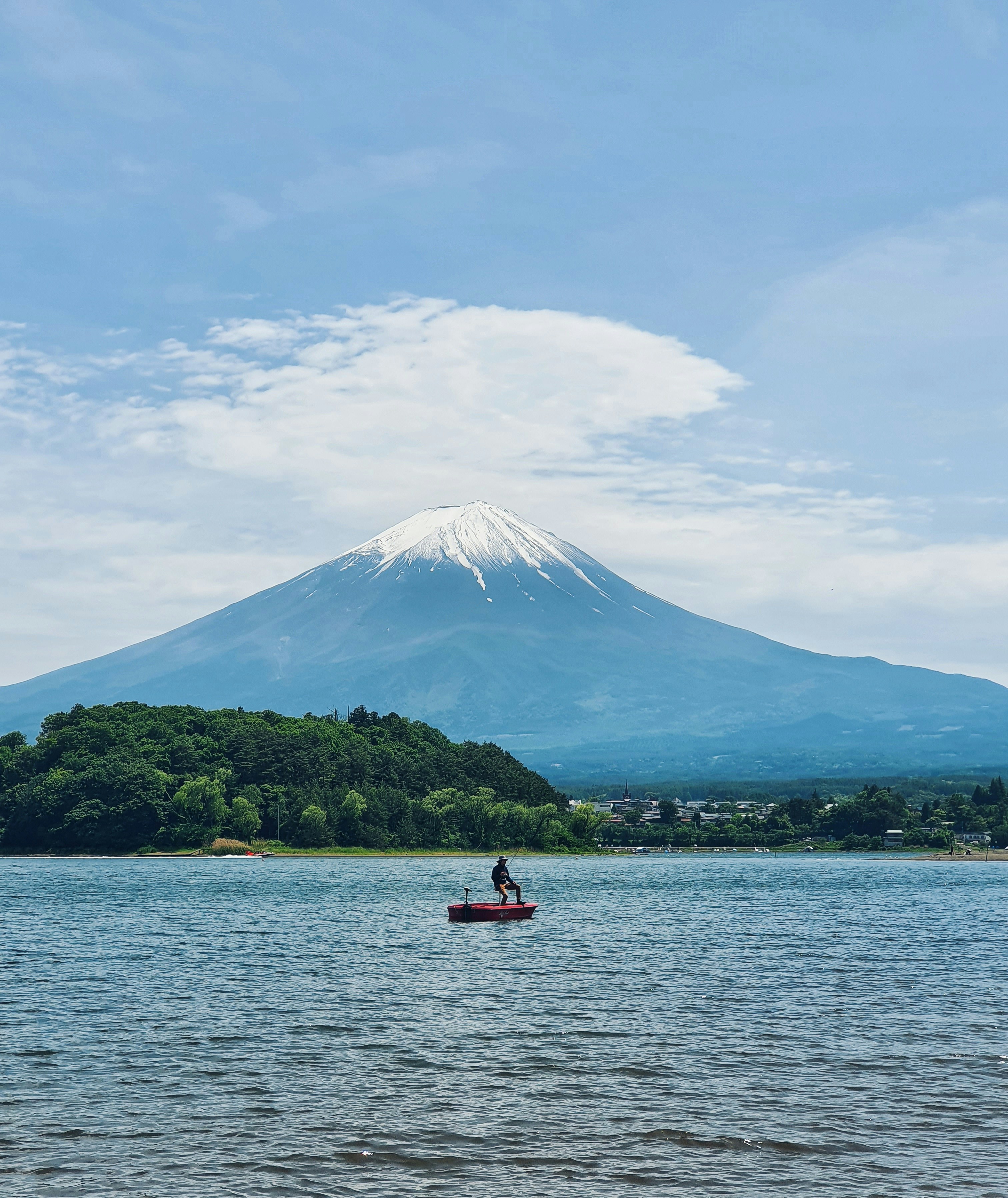 a person in a boat on a lake with a mountain in the background
