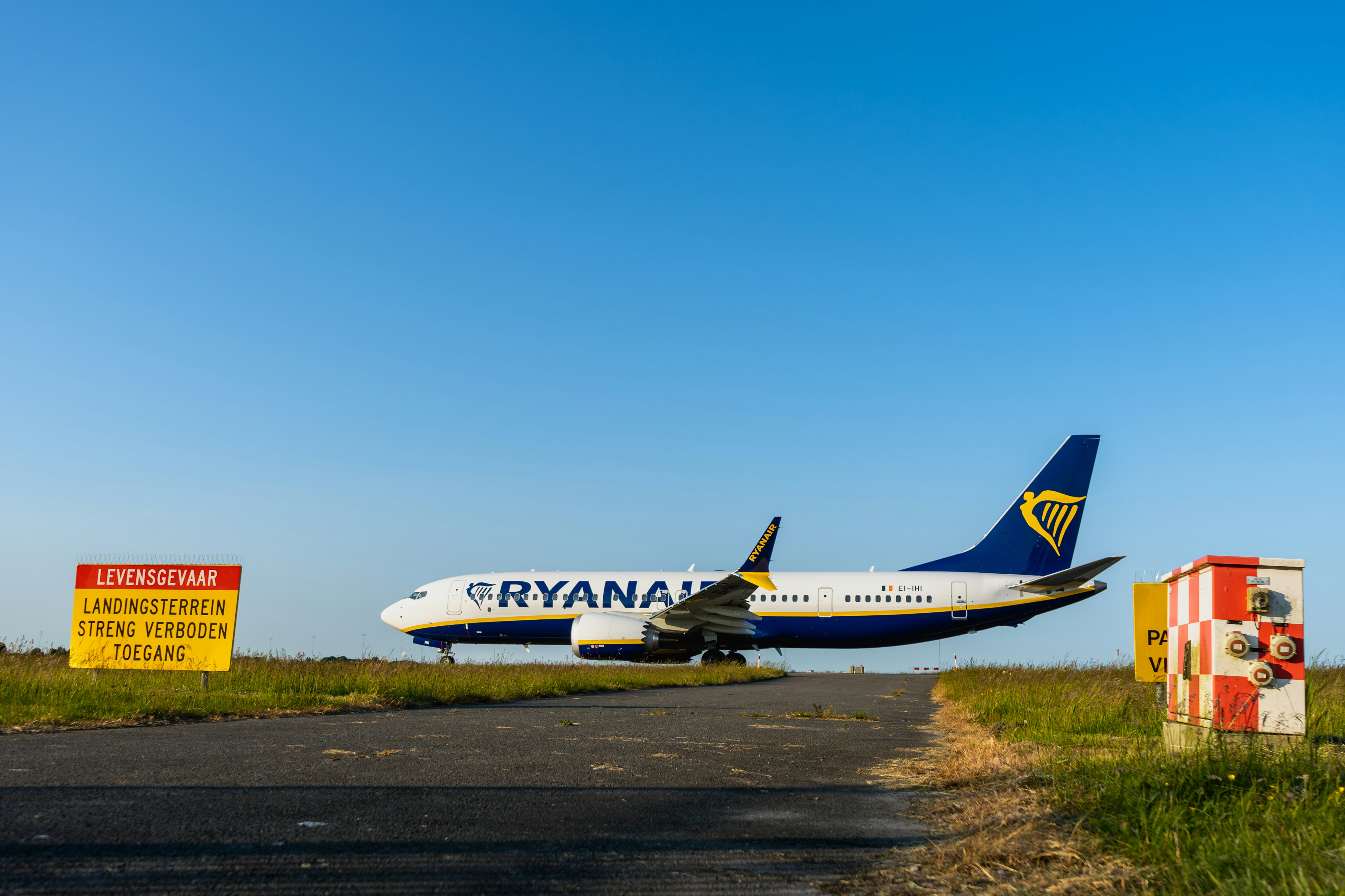 a large jetliner sitting on top of an airport runway, Ryanair flight FR3101 to Dublin (a Boeing 737 MAX 8-200, reg. EI-IHI) taxiing to the Polderbaan runway at Schiphol airport for departure.
