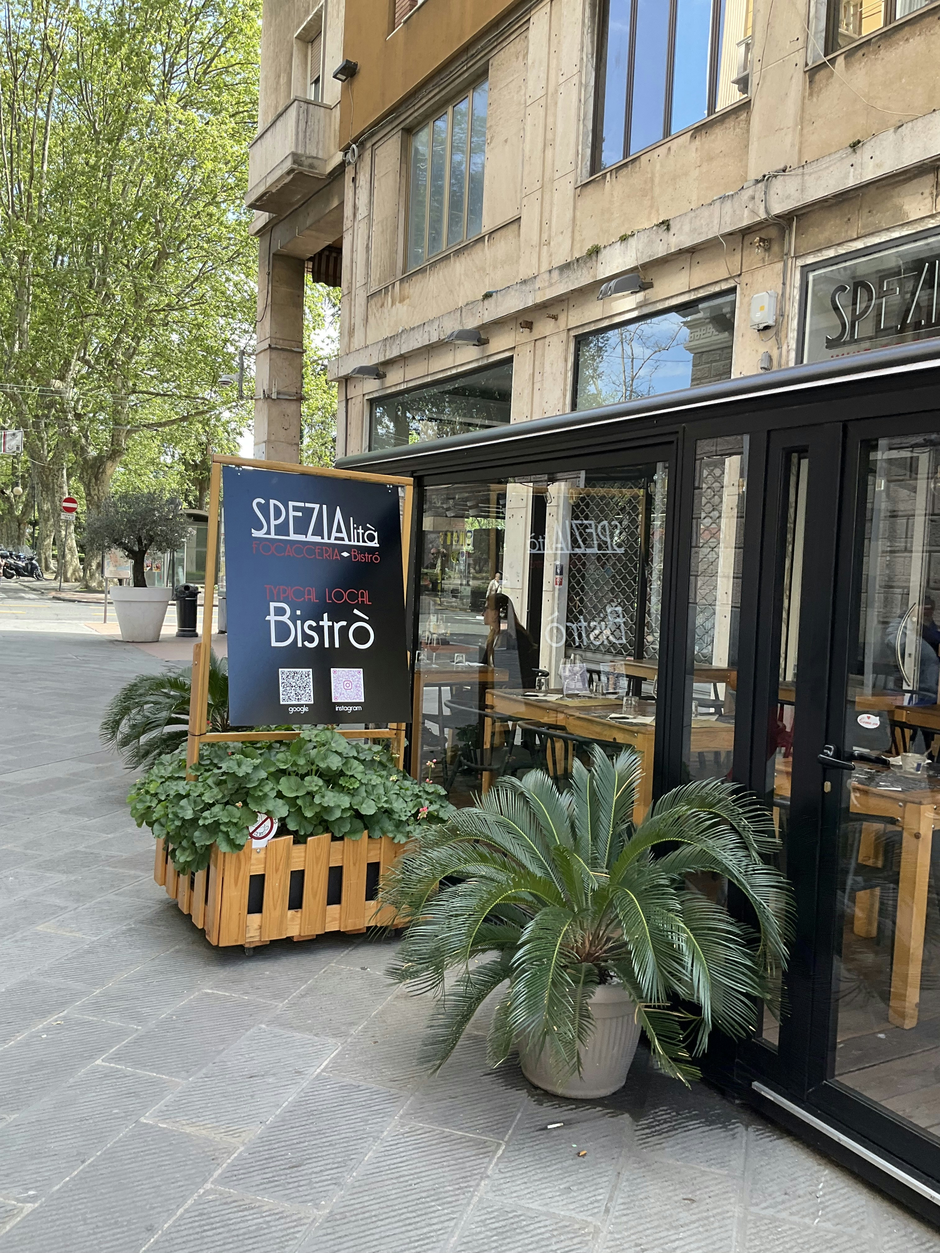 a store front with a plant in front of it