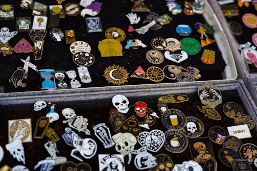 Photo of collectible pins displayed on a denim jacket sleeve.