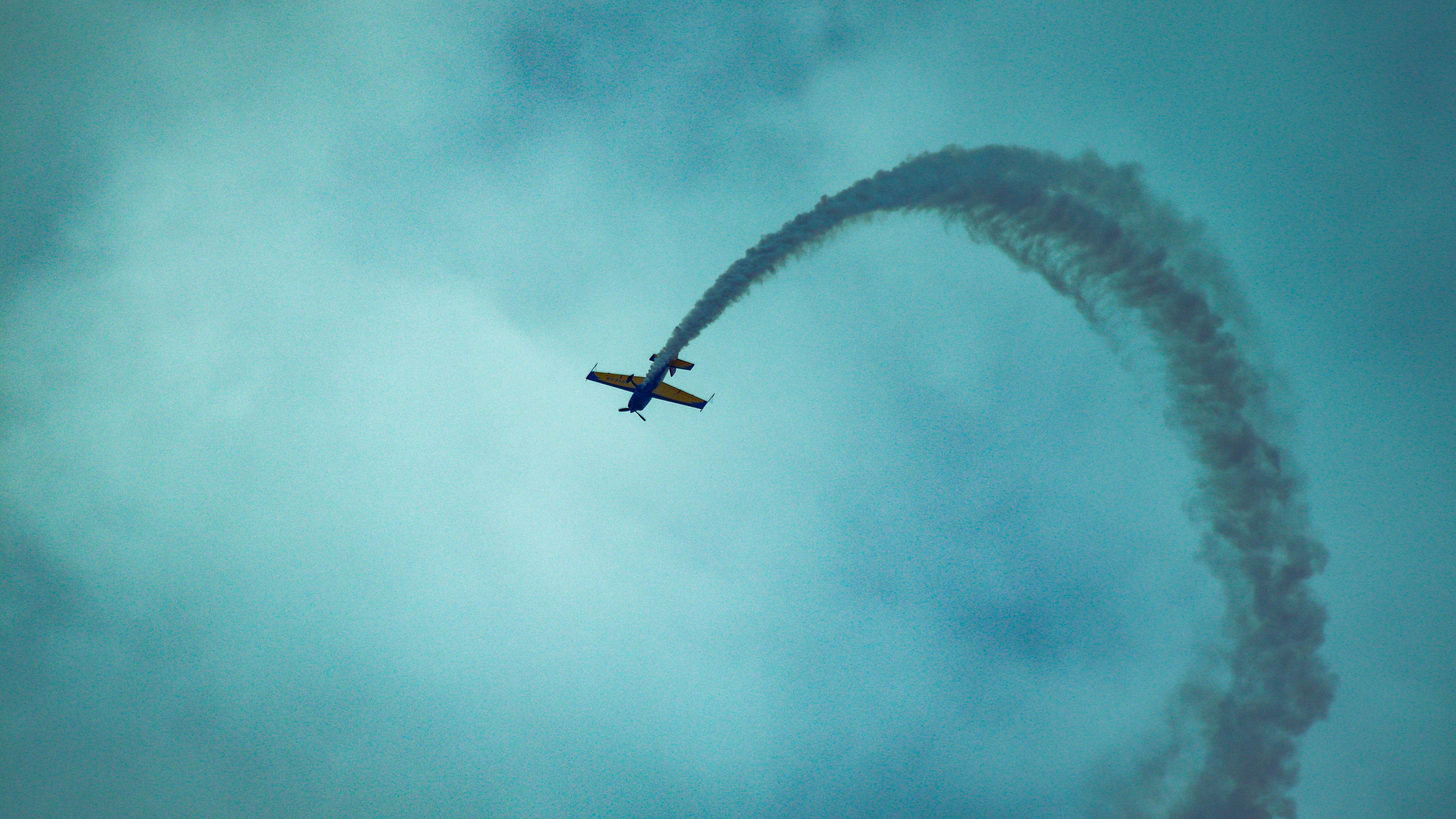 an airplane flying in the sky with a smoke trail behind it