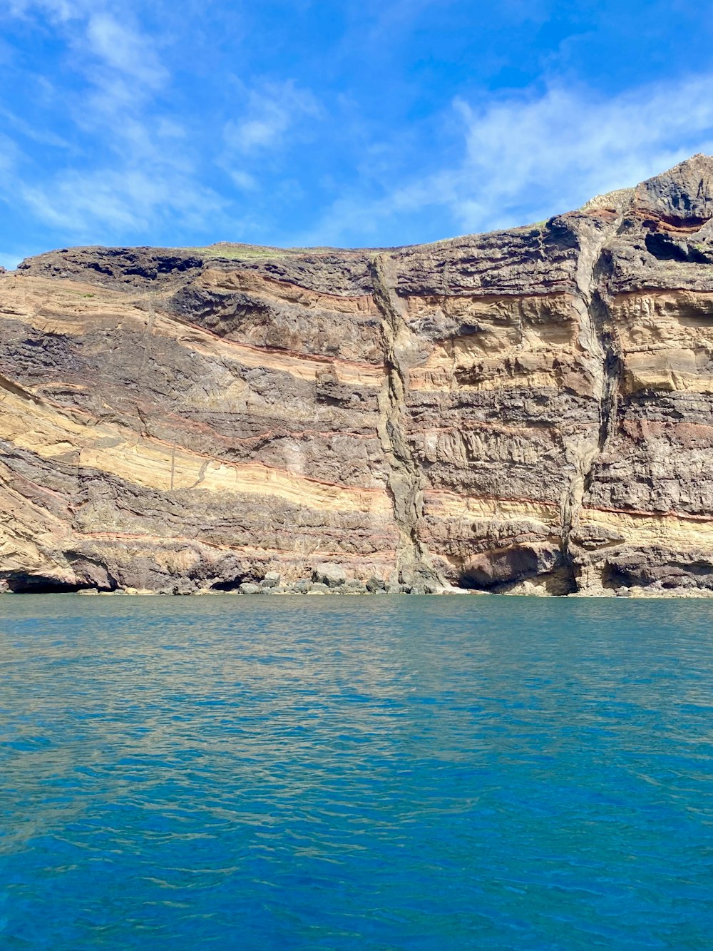 a large body of water with a cliff in the background