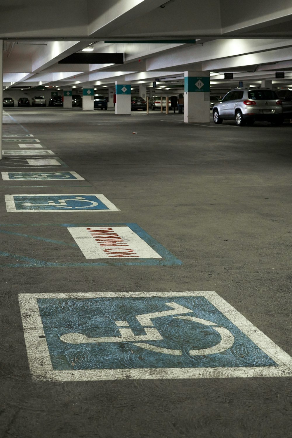 an empty parking garage with blue and white signs
