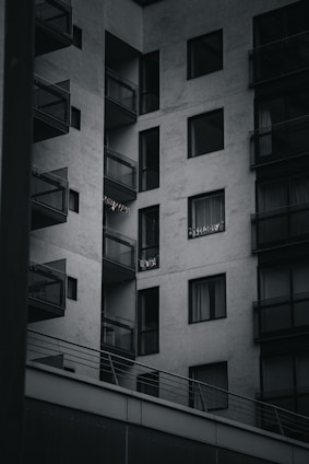 A modern apartment building with large windows and a balcony.