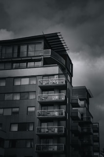 Contemporary condo building with balconies overlooking a cityscape.