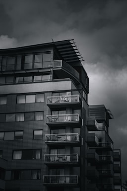 Contemporary condo building with balconies overlooking a cityscape.