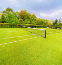 Gepflegter Rasen-Tennisplatz mit Netz