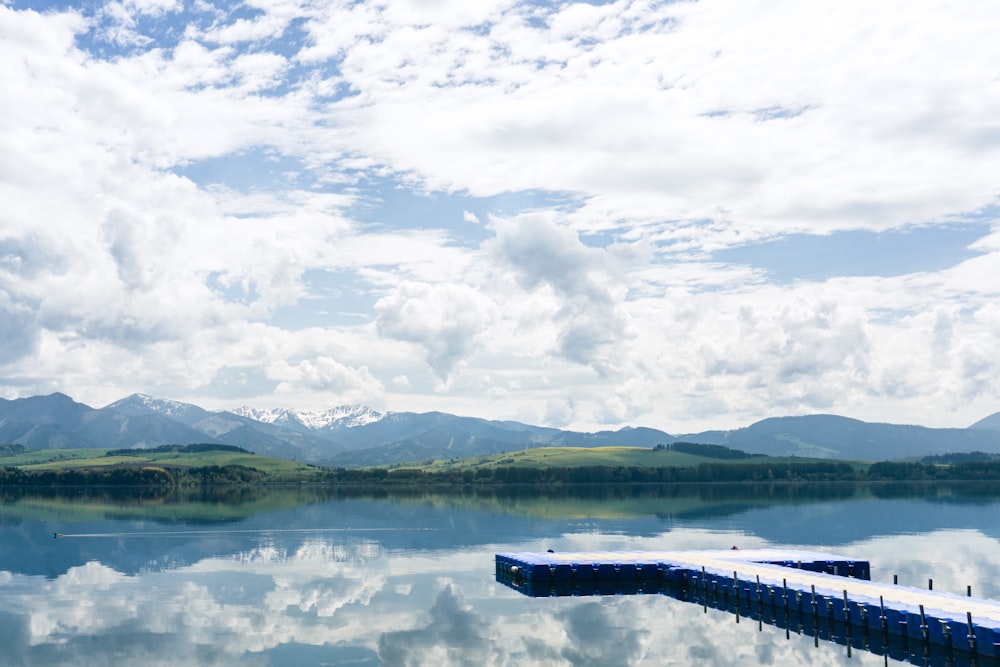 a pier sitting on top of a lake under a cloudy sky