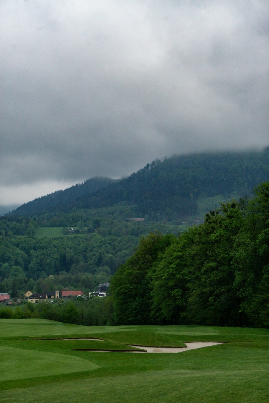 Golfplatz mit Bergkulisse im Morgennebel (Symbolbild)