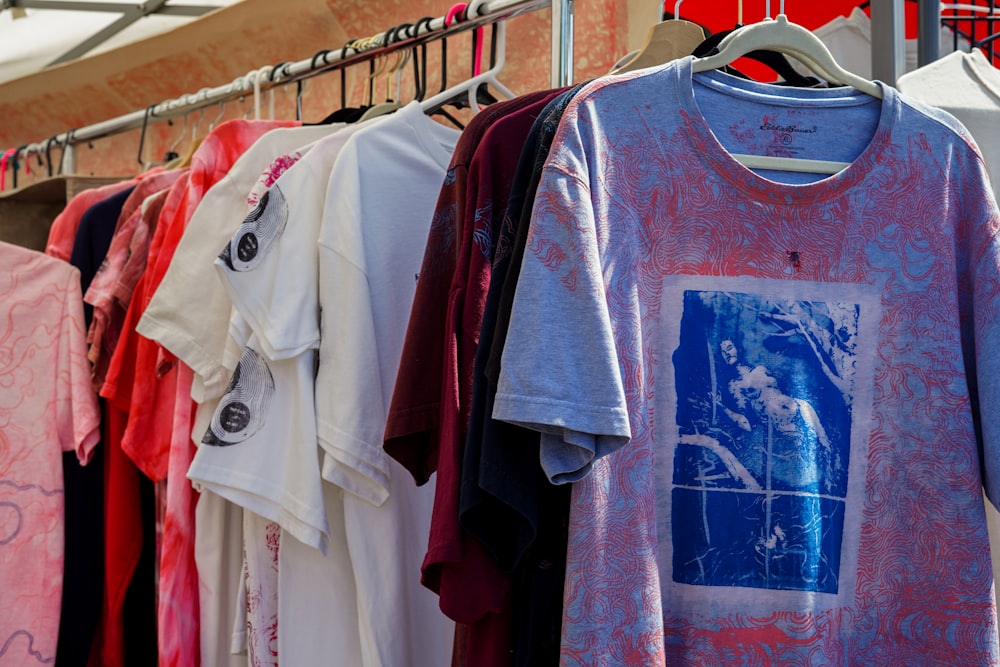 a bunch of shirts hanging on a rack