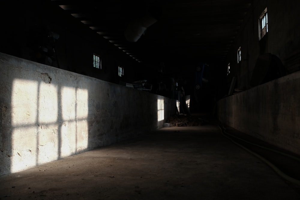 a dimly lit room with windows and a wall