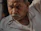 Close-up of a confident middle-aged man with smooth skin, seated in a modern clinic room.