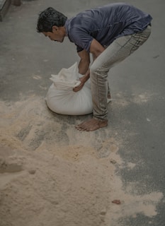 a man standing over a bag of sand