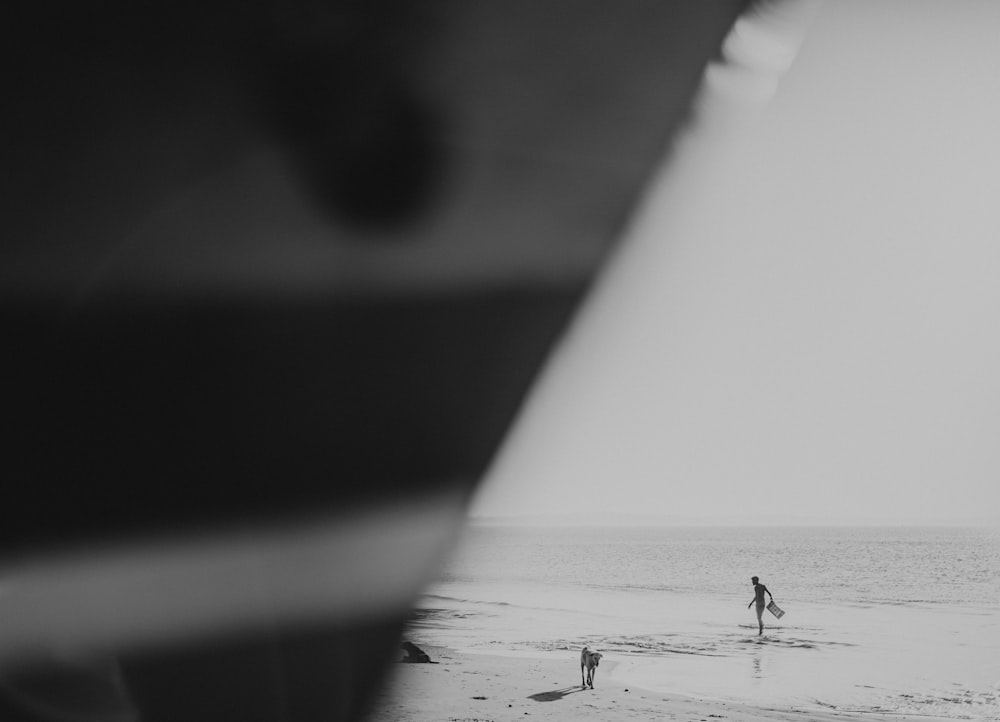 a person standing on a beach with a surfboard