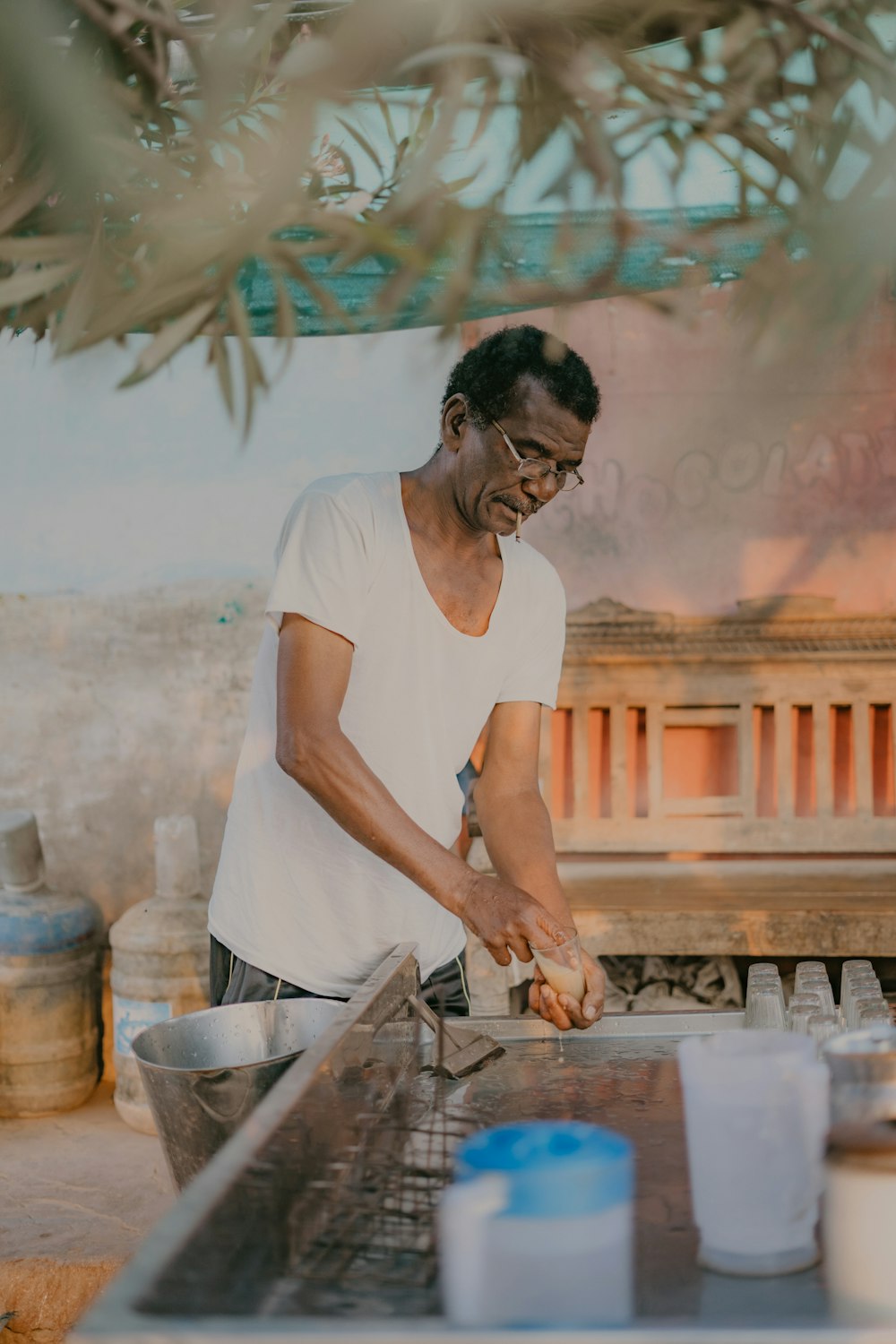 a man in a white shirt is cooking on a grill