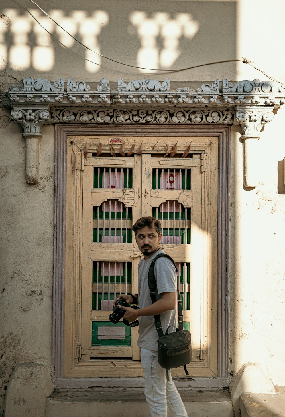 a man standing in front of a door holding a camera