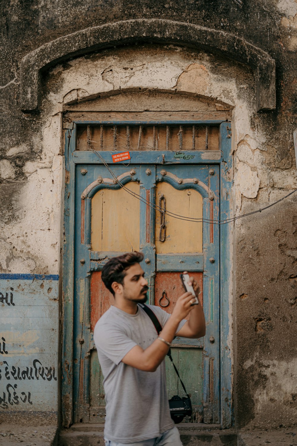 a man holding a cell phone in front of a door