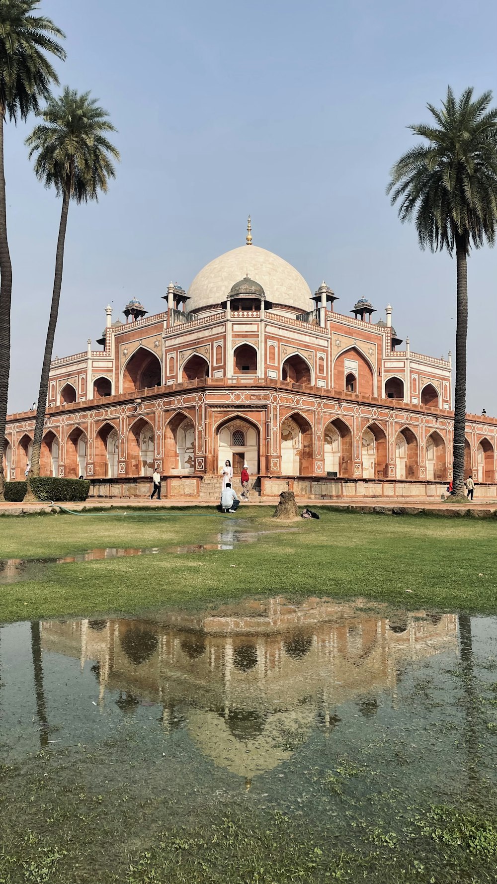 a large building sitting next to a lush green field