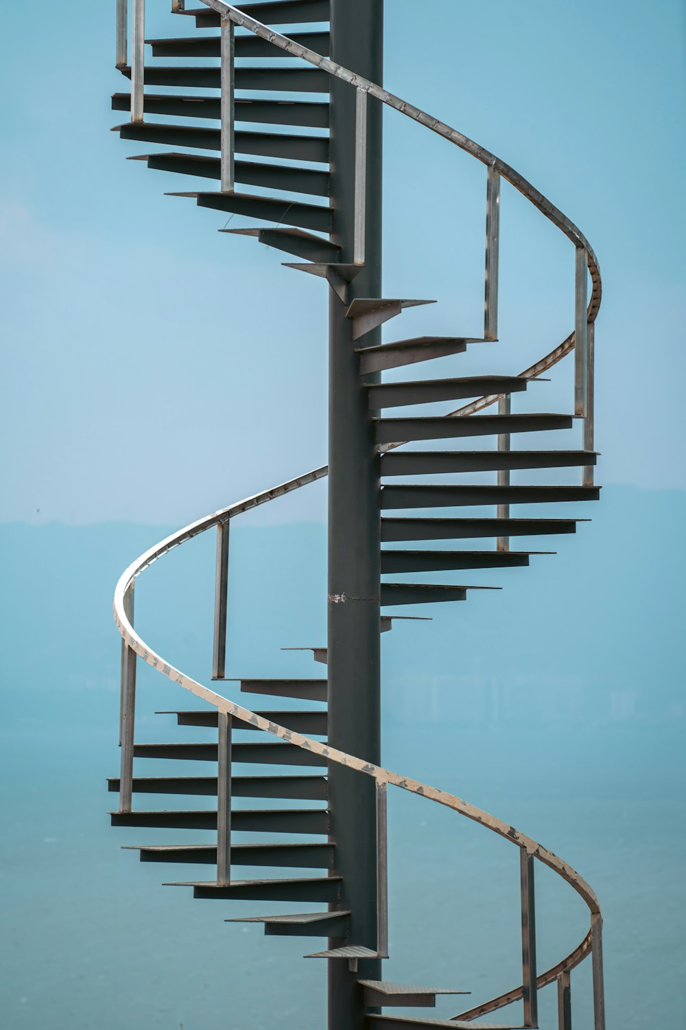 a metal spiral staircase against a blue sky