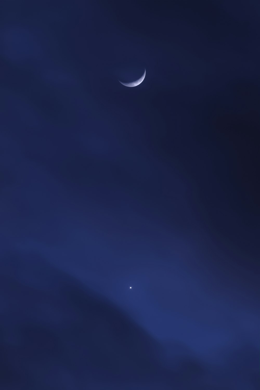 a night sky with the moon and two stars