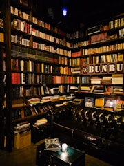 Cozy library corner with warm lighting and shelves filled with books.