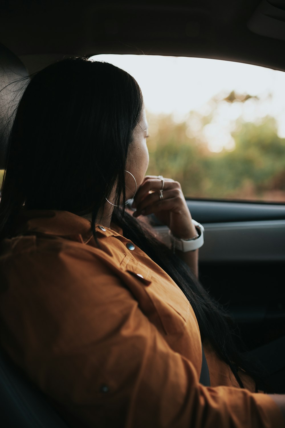 a woman sitting in a car talking on a cell phone