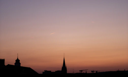 A sleek architectural blueprint overlaying a city skyline at dusk.