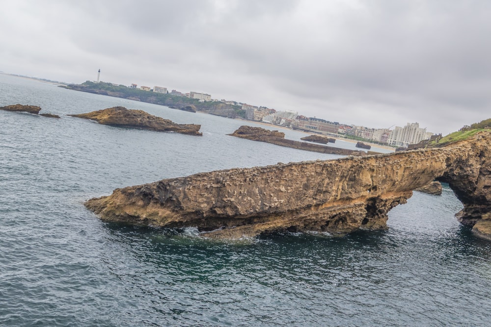 a large rock formation in the middle of a body of water