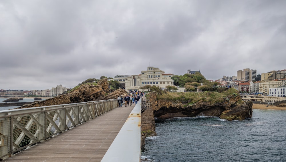 a group of people walking across a bridge over a body of water