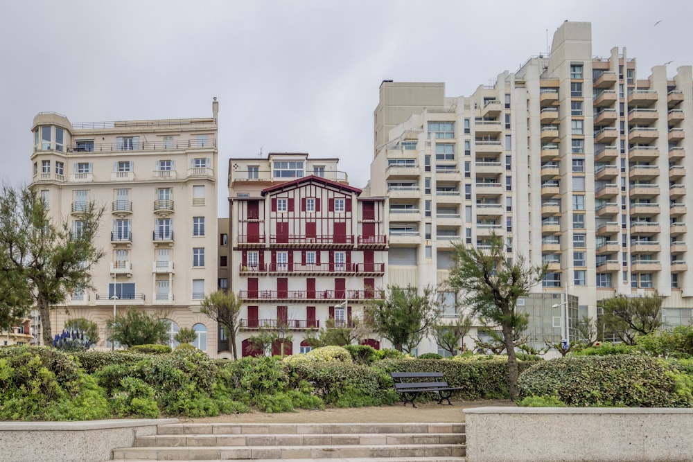 Un edificio con persianas rojas y un banco frente a él