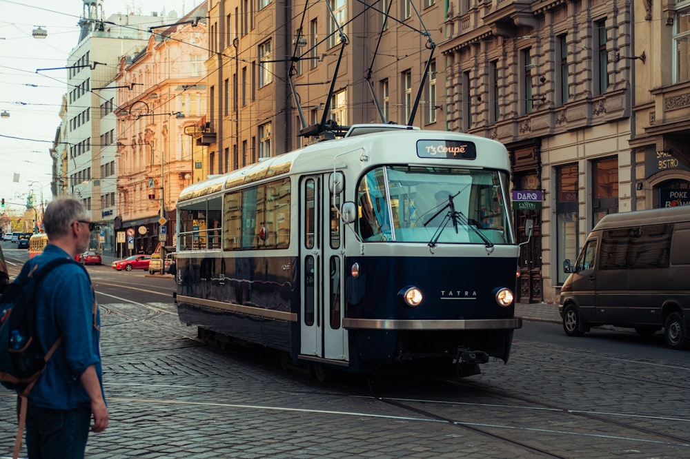 a man walking down a street next to a trolley